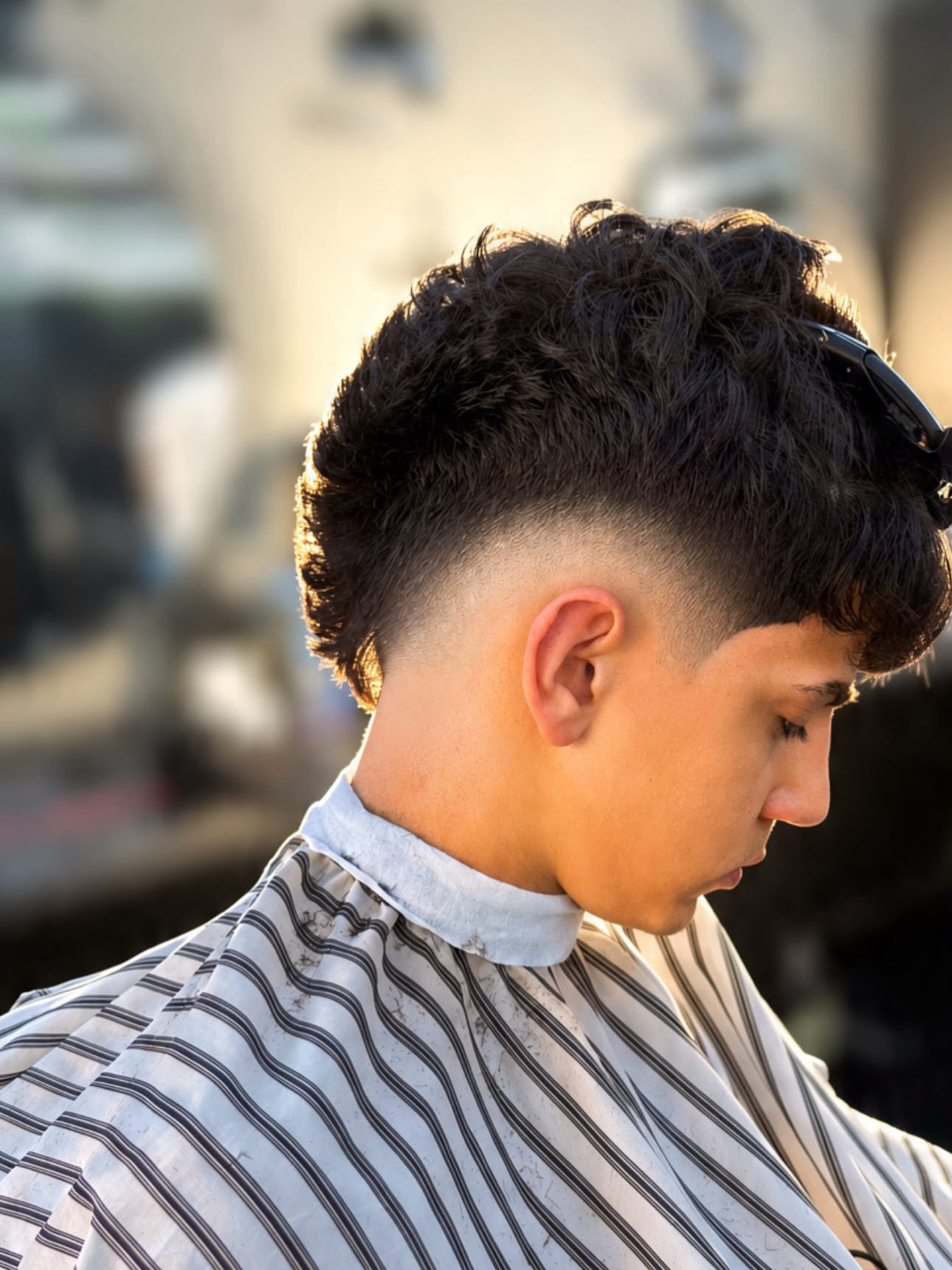 Curly top with a sharp fade by Kritikos Barbershop